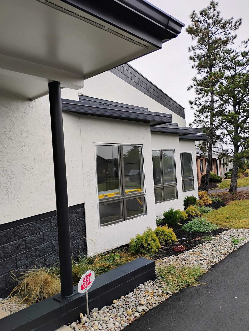 Commercial building with white stucco and charcoal trim and block