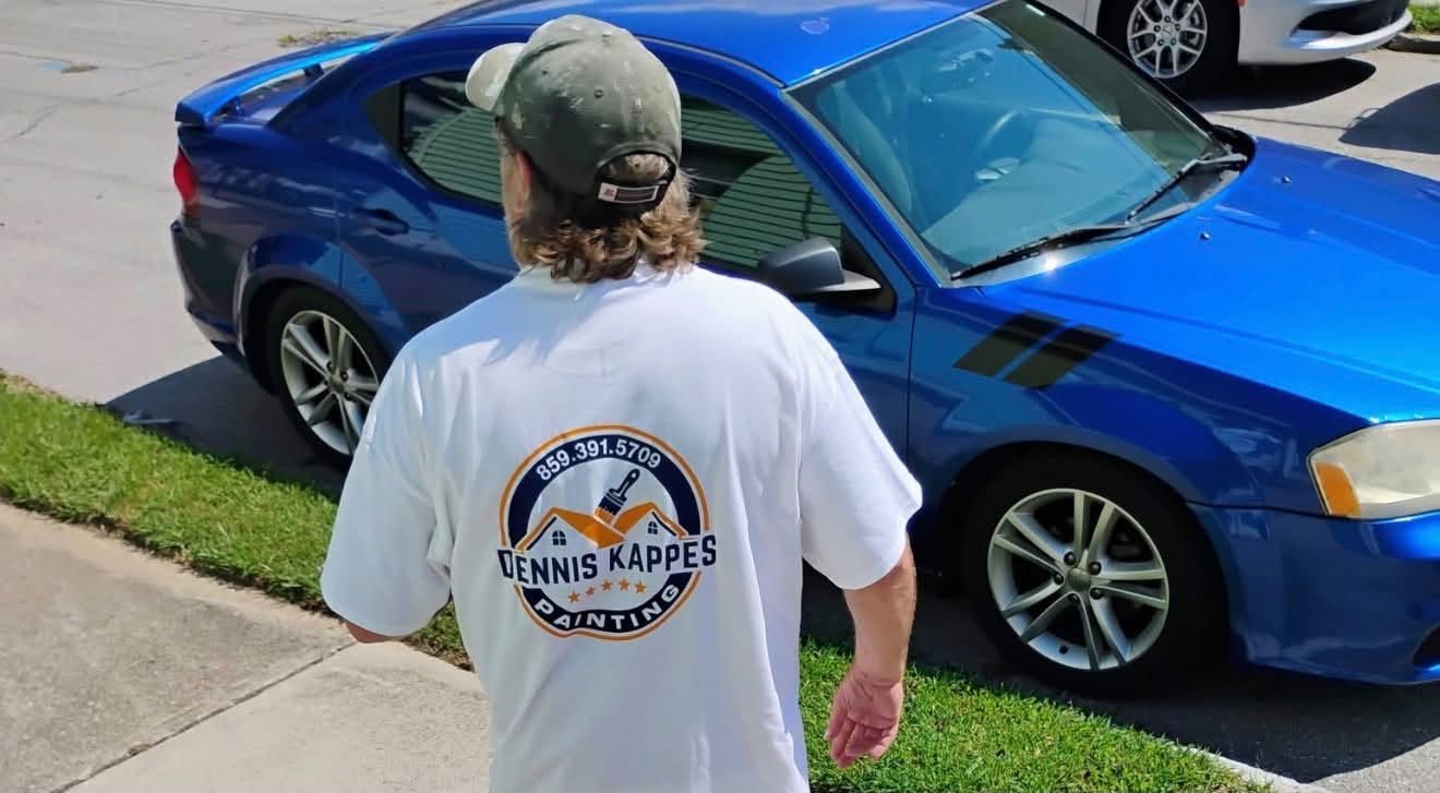 A Dennis Kappes Painting crew member walking up to a job in a white shirt with the company logo on the back