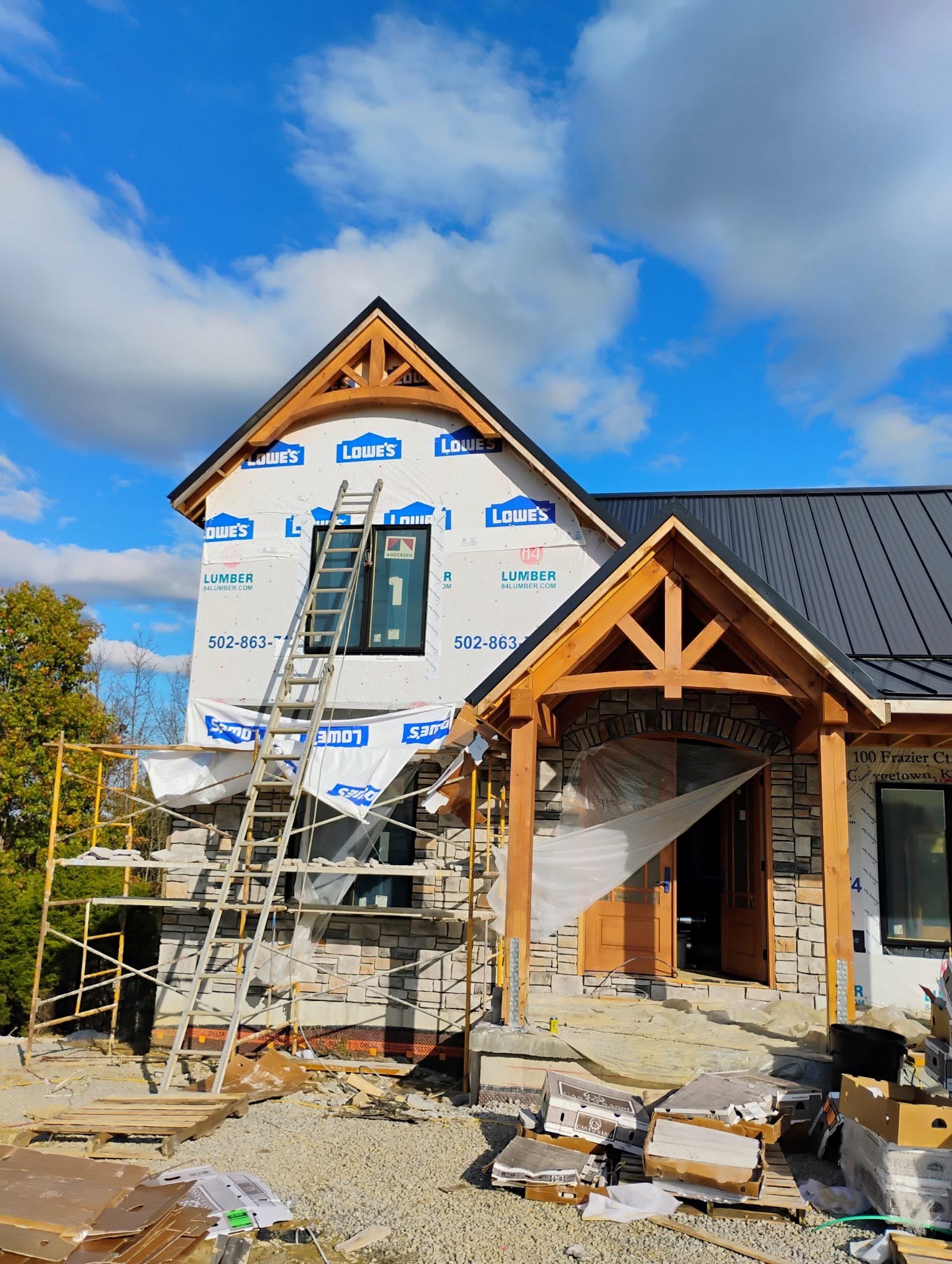 A stone-and-timber home under construction, ready for exterior finishing.
