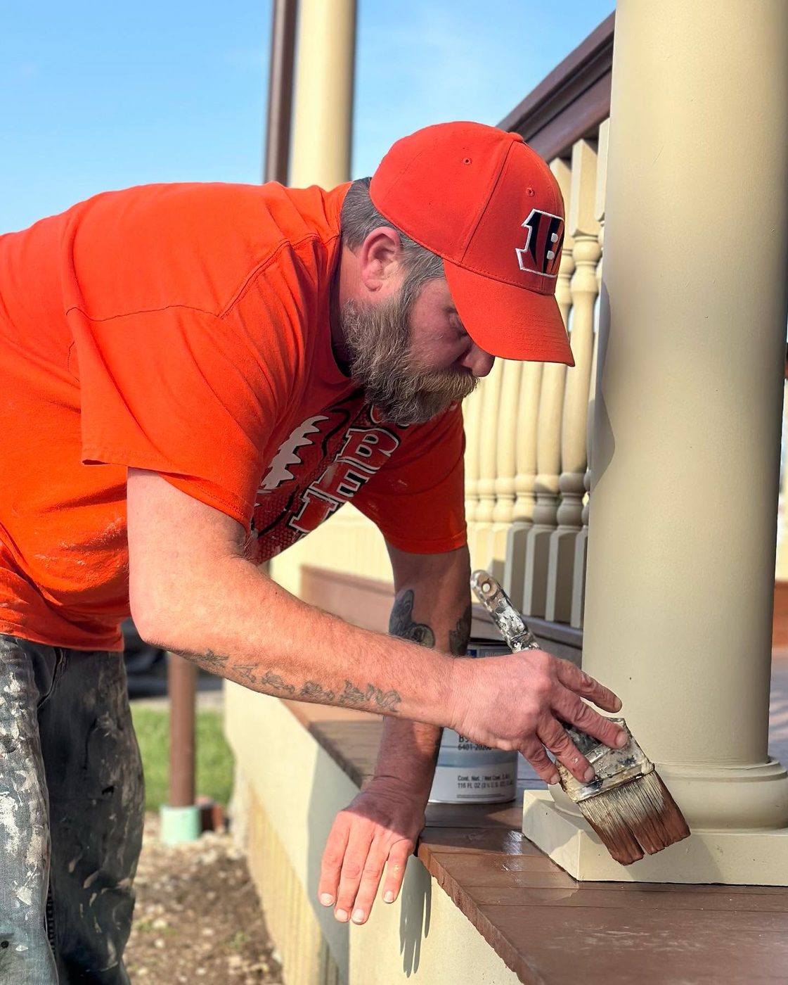 Dennis Kappes brushing paint onto a porch column