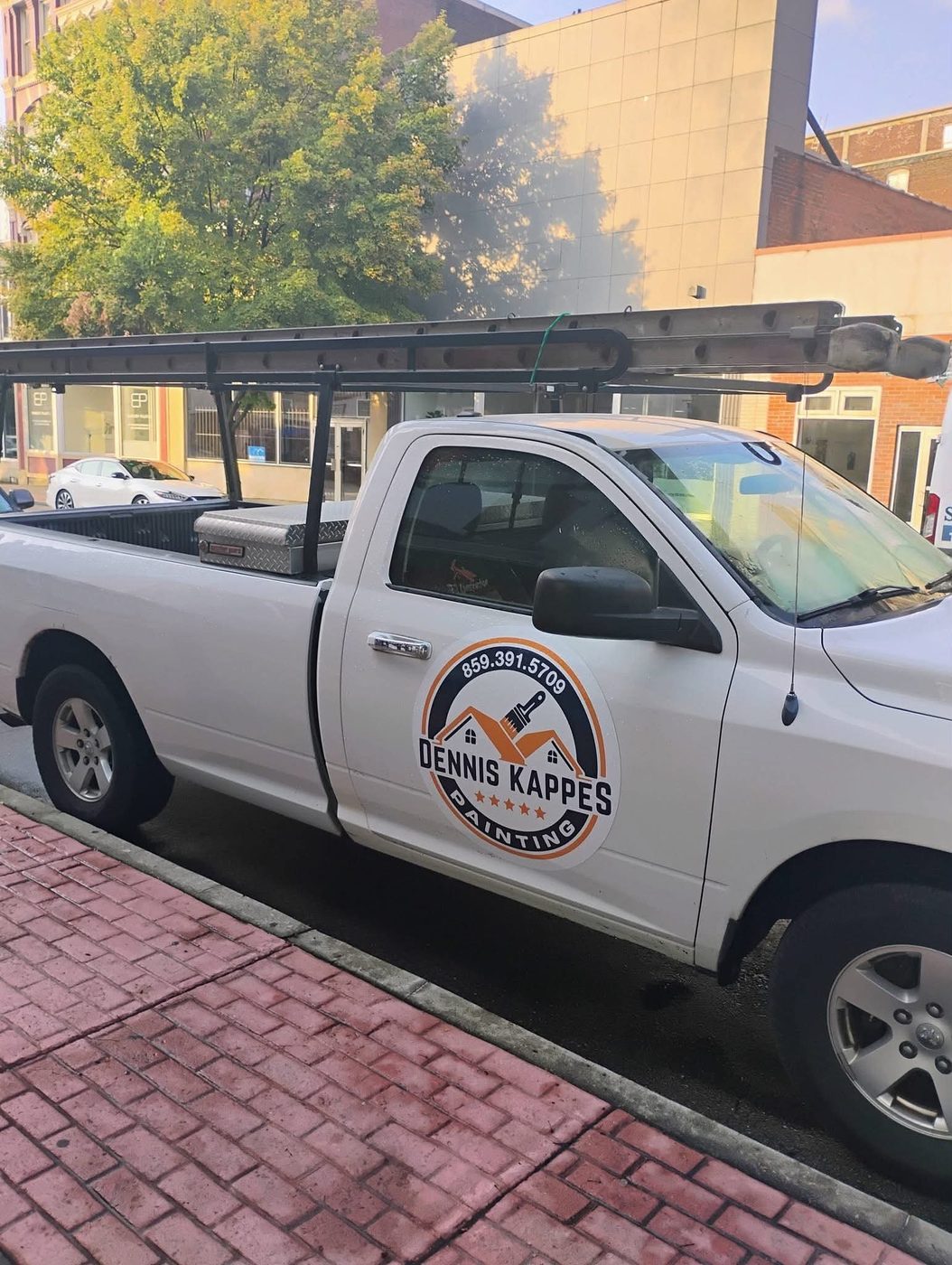 The Dennis Kappes Painting truck with a ladder rack and logo on the door